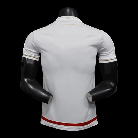 Maillot de football AS Monaco blanc et rouge pour homme, avec détails dorés sur les manches et le col. Logo de l'équipe sur la poitrine.