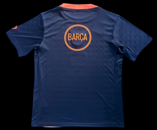 Maillot de football FC Barcelone bleu marine pour homme avec inscription BARÇA orange au dos. Tissu respirant.