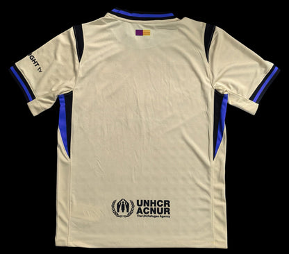Maillot de football My Store 4, beige, col et manches bleus et noirs, logo UNHCR ACNUR au dos. Tissu respirant.