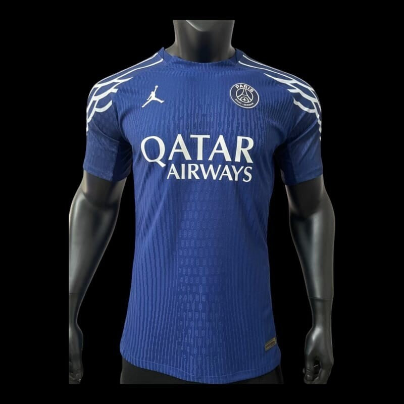 Maillot de football domicile Paris Saint-Germain bleu marine avec logo du club, sponsor Qatar Airways et Swoosh Nike. Manches courtes, col rond, détails graphiques blancs sur les épaules.