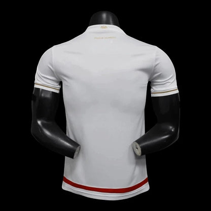 Maillot de football AS Monaco blanc et rouge pour homme, avec détails dorés sur les manches et le col. Logo de l'équipe sur la poitrine.