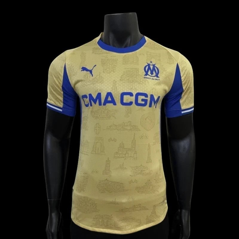 Maillot de football Olympique de Marseille domicile doré avec détails bleus, sponsor CMA CGM, logo Puma et blason OM.