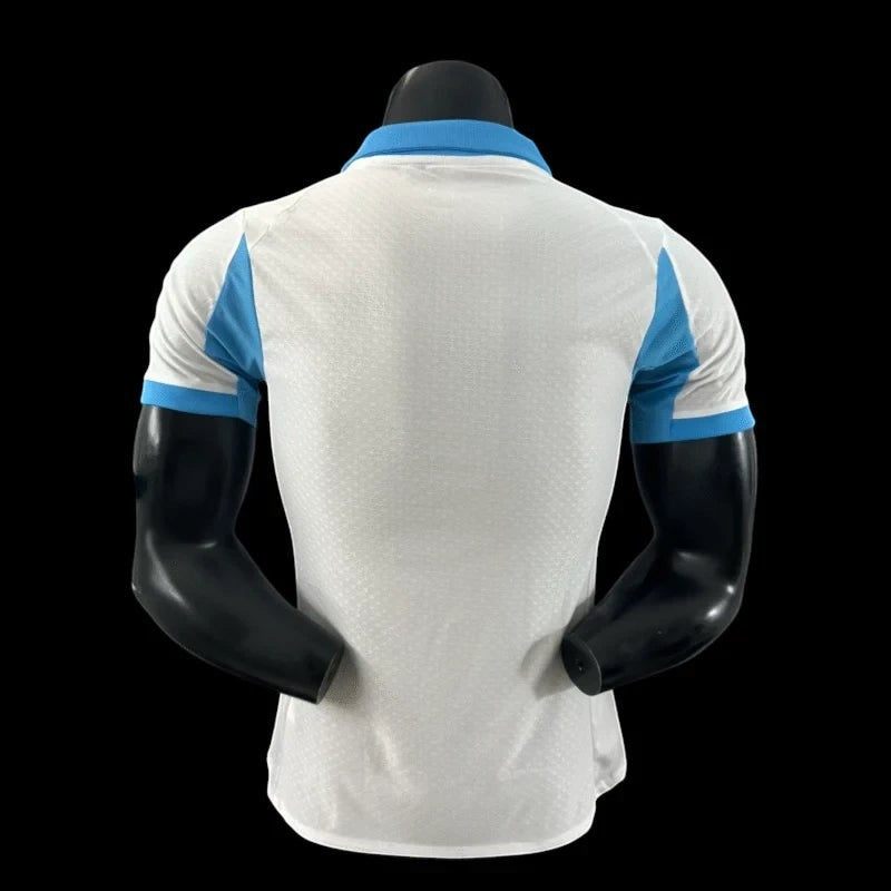 Maillot de football Olympique de Marseille blanc pour homme, col et épaules bleu ciel, tissu respirant, logo OM et Puma, sponsor CMA CGM.