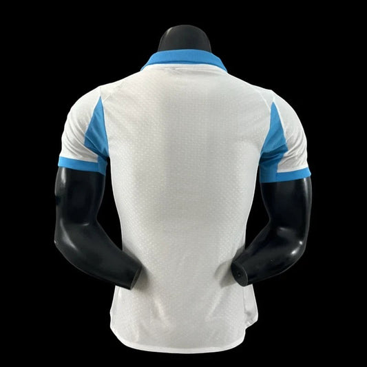 Maillot de football Olympique de Marseille blanc pour homme, col et épaules bleu ciel, tissu respirant, logo OM et Puma, sponsor CMA CGM.