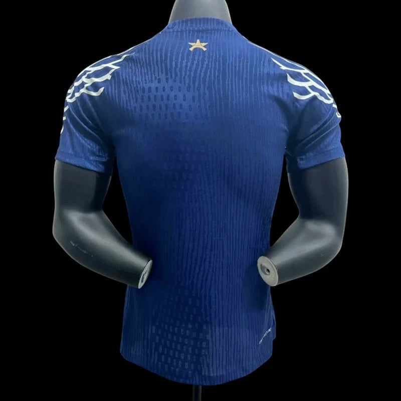 Maillot de football bleu marine Paris Saint-Germain pour homme, avec un motif texturé et des détails blancs sur les épaules. Logo étoile doré sur la nuque.