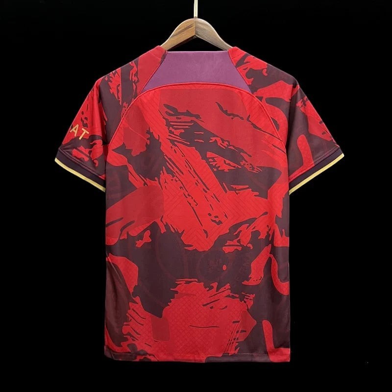 Maillot de football Paris Saint-Germain édition spéciale rouge et bordeaux avec motifs abstraits et détails dorés. Tissu respirant.