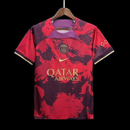 Maillot de football Paris Saint-Germain édition spéciale rouge et bordeaux avec logos dorés et détails graphiques abstraits. Tissu respirant.