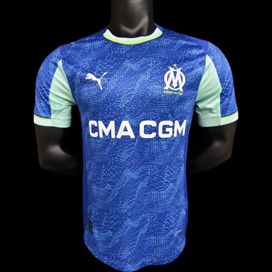Maillot de football Olympique de Marseille bleu avec logo Puma et CMA CGM. Manches et col vert menthe.