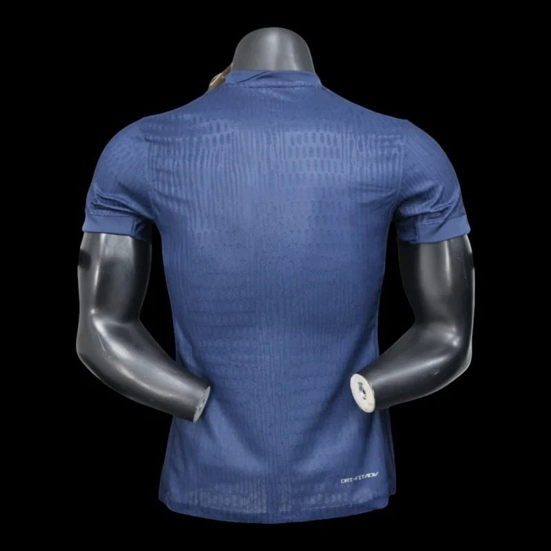 Maillot de football Paris Saint-Germain bleu marine pour homme, technologie Dri-FIT, motif graphique subtil, logo PSG et Swoosh Nike.